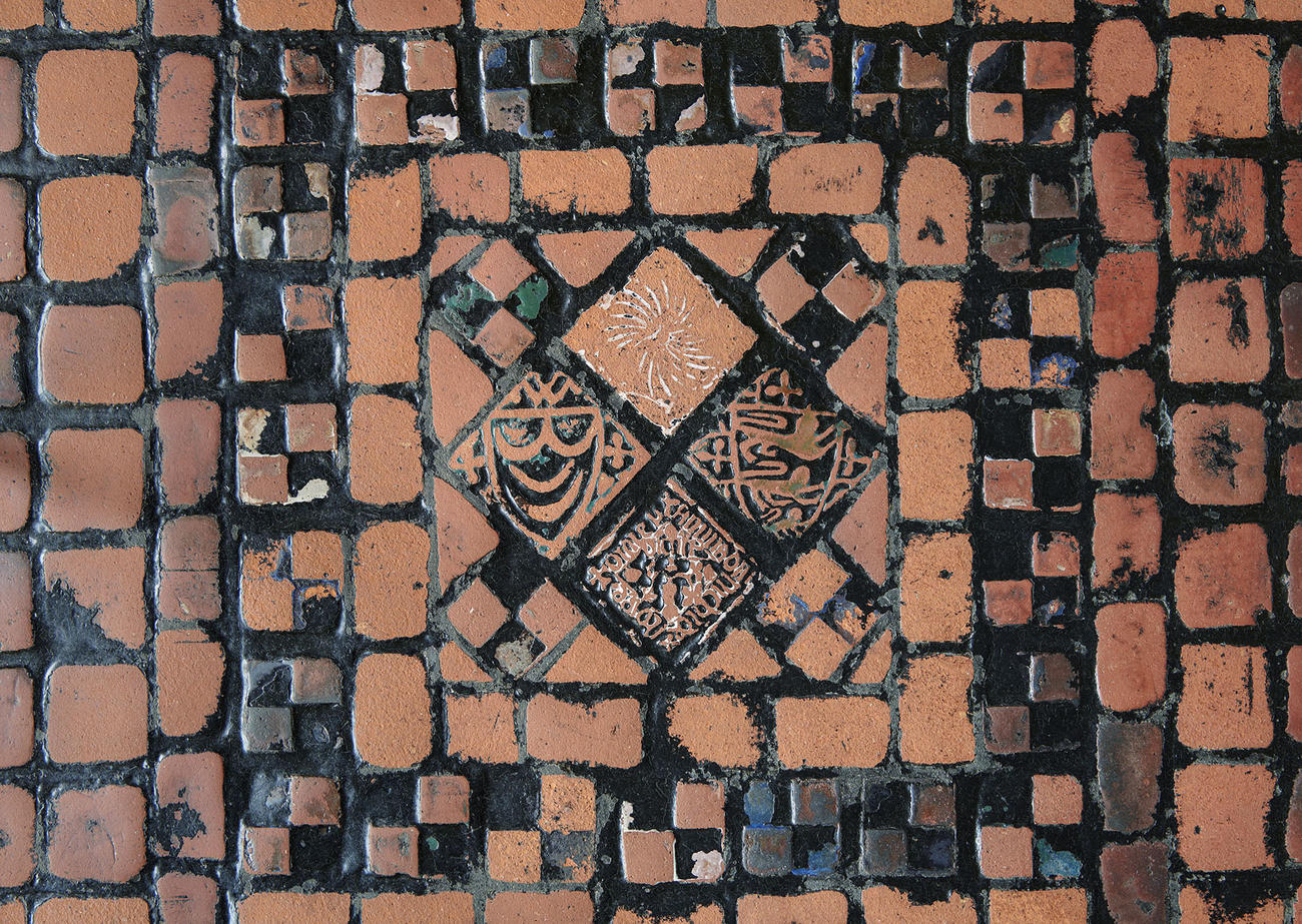 Two photographs of the brick red floor tiles in the Gothic Room before and after a cleaning.