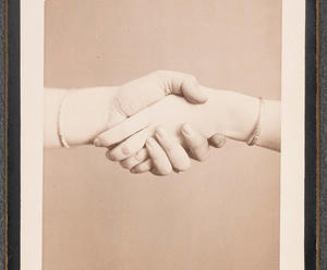 A black and white photograph of two hands clasped.
