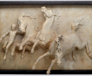 Plaster cast picture of three horses and a man in a frame.