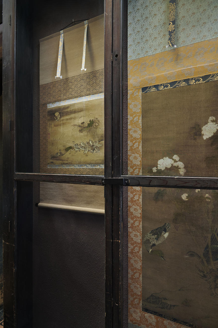 The glass display case in the Third Floor Passage in December 2022 with reproductions of two Chinese paintings of birds.
