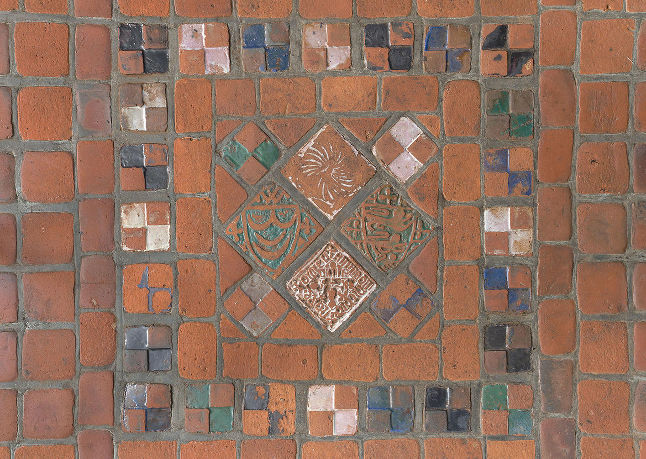 Two photographs of the brick red floor tiles in the Gothic Room before and after a cleaning.