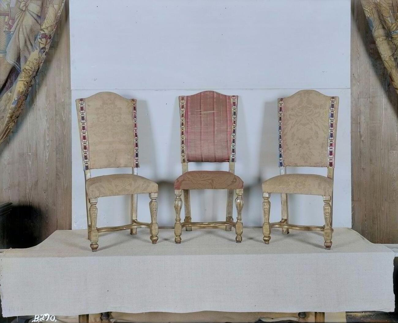 Black and white photograph of three chairs laid over a colorized photograph. The fabric on the middle chair is pink striped.