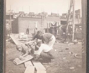 A black and white photograph of the Gardner Museum construction site with three men bent over picking up a stone sculpture of a lion.