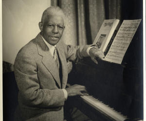 Musician sitting at piano.