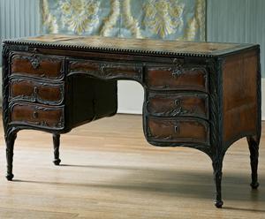 Dark brown desk with seven drawers, three on each side and one in the middle, and edge detailing that resembles pine needles in the Gardner Museum’s Blue Room