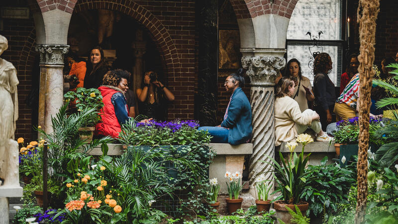 Large group of diverse visitors sitting and standing around the courtyard