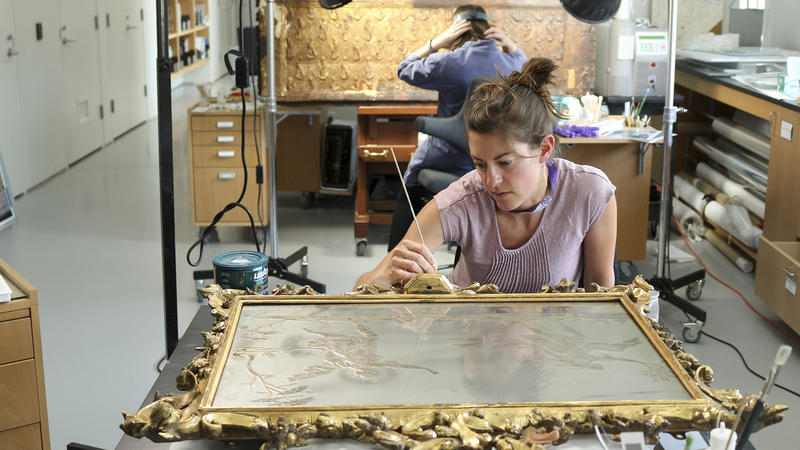 An ornate frame being worked on in the Isabella Stewart Gardner conservation labs