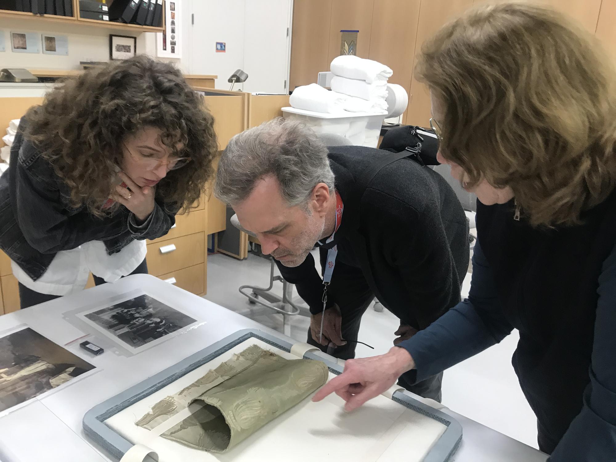 Mary Reid Kelley and Patrick Kelley look at an original fragment of the dress Gardner cut apart and installed under Titian’s Europa, 2019