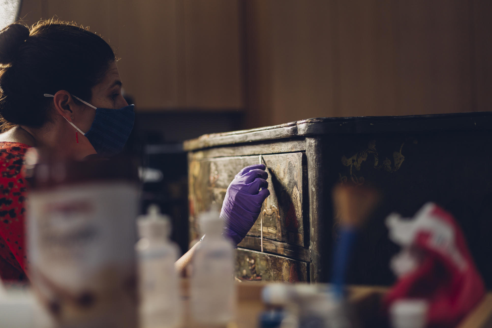 Jess Chloros removes discolored varnish from an object