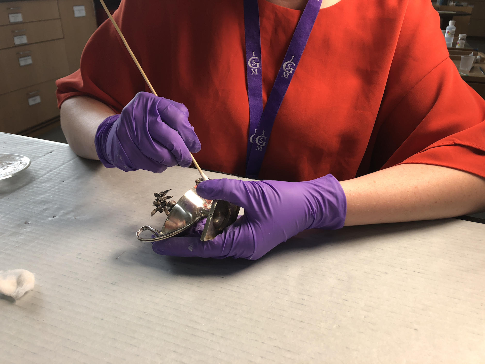 Kaeley Ferguson, Conservation Technician, removing tarnish on a salt cellar