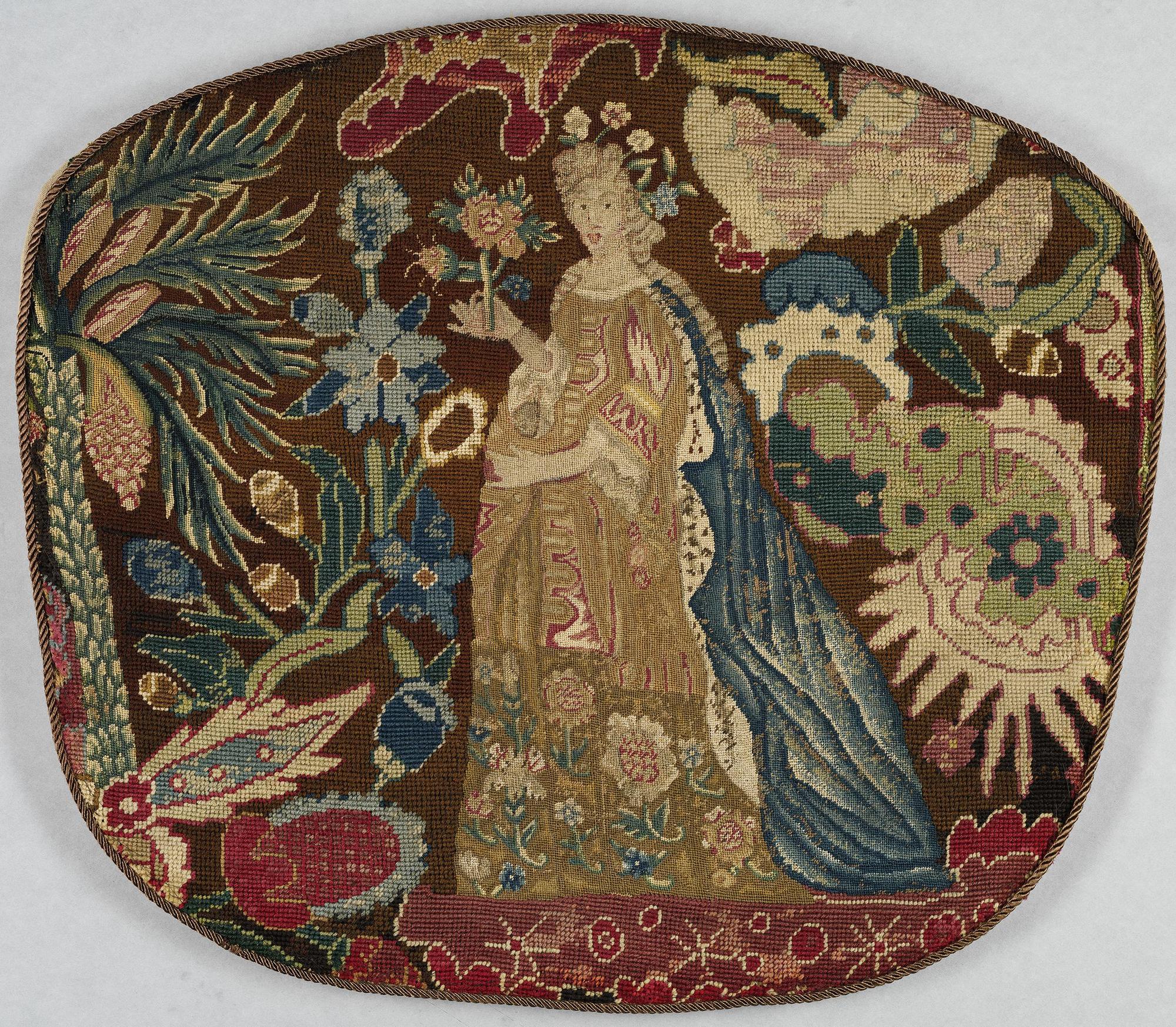 A sewn piece with a woman in a dress surrounded by plants