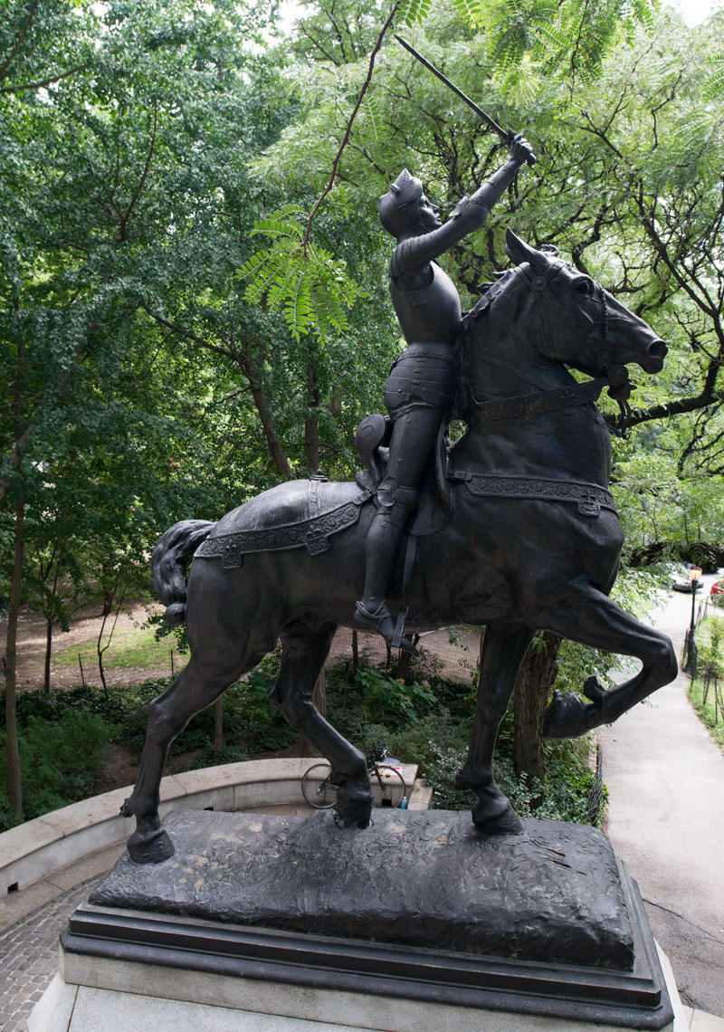 A side view of a statue of Joan of Arc on a horse
