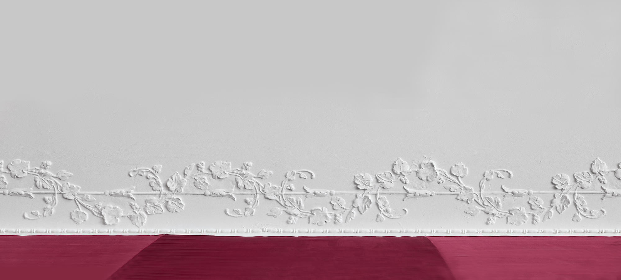 Molding on a white wall with a red banner underneath.