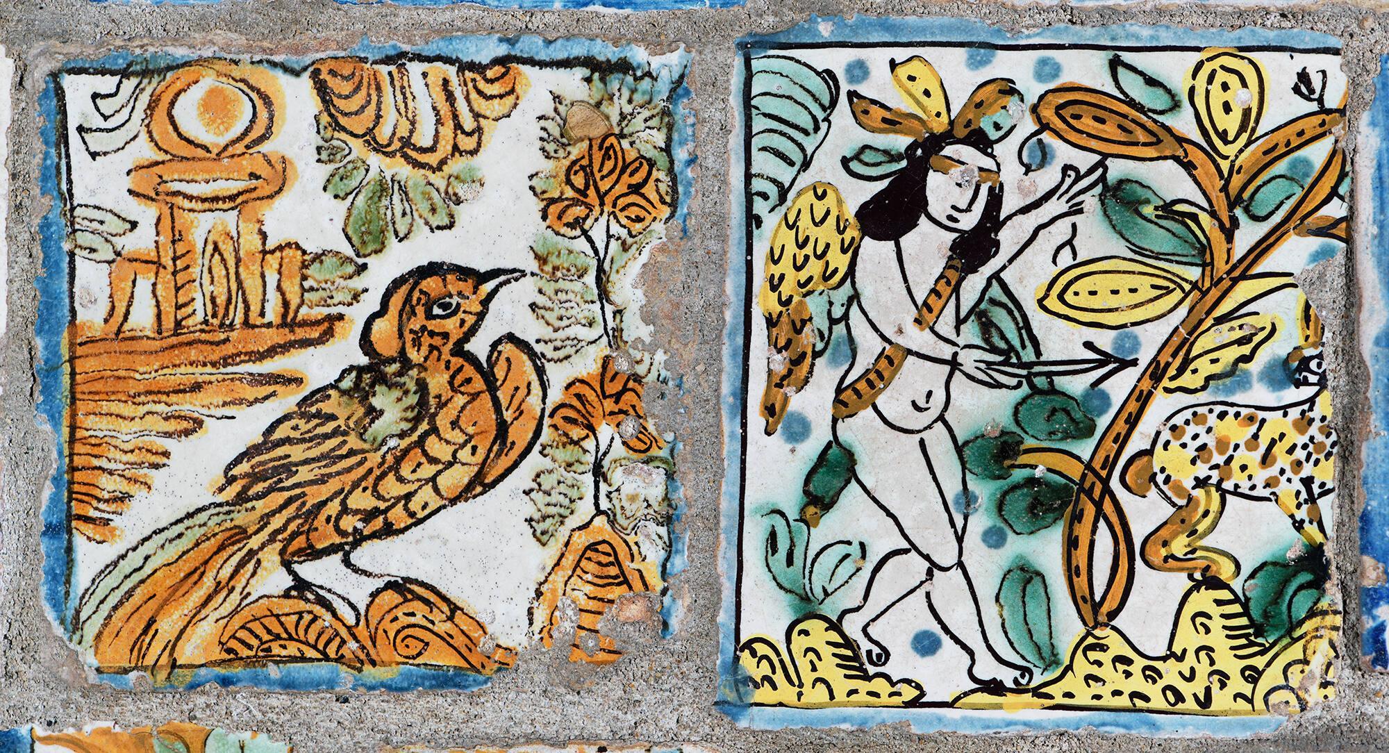 A tile with an orange bird painted on the left and a tile with a naked person painted on the right.