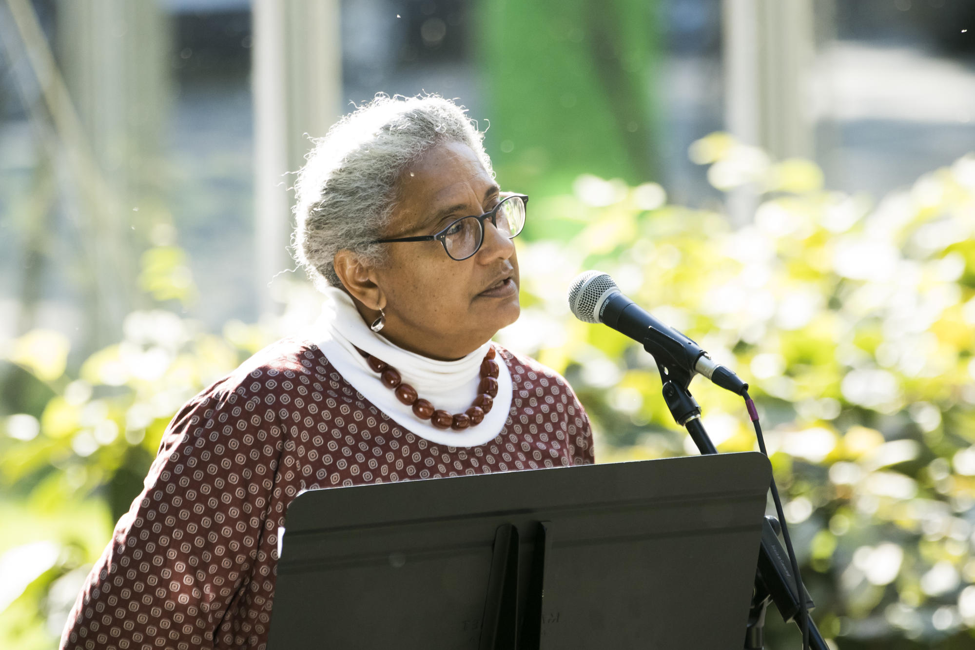 A woman talks at a podium into a microphone.