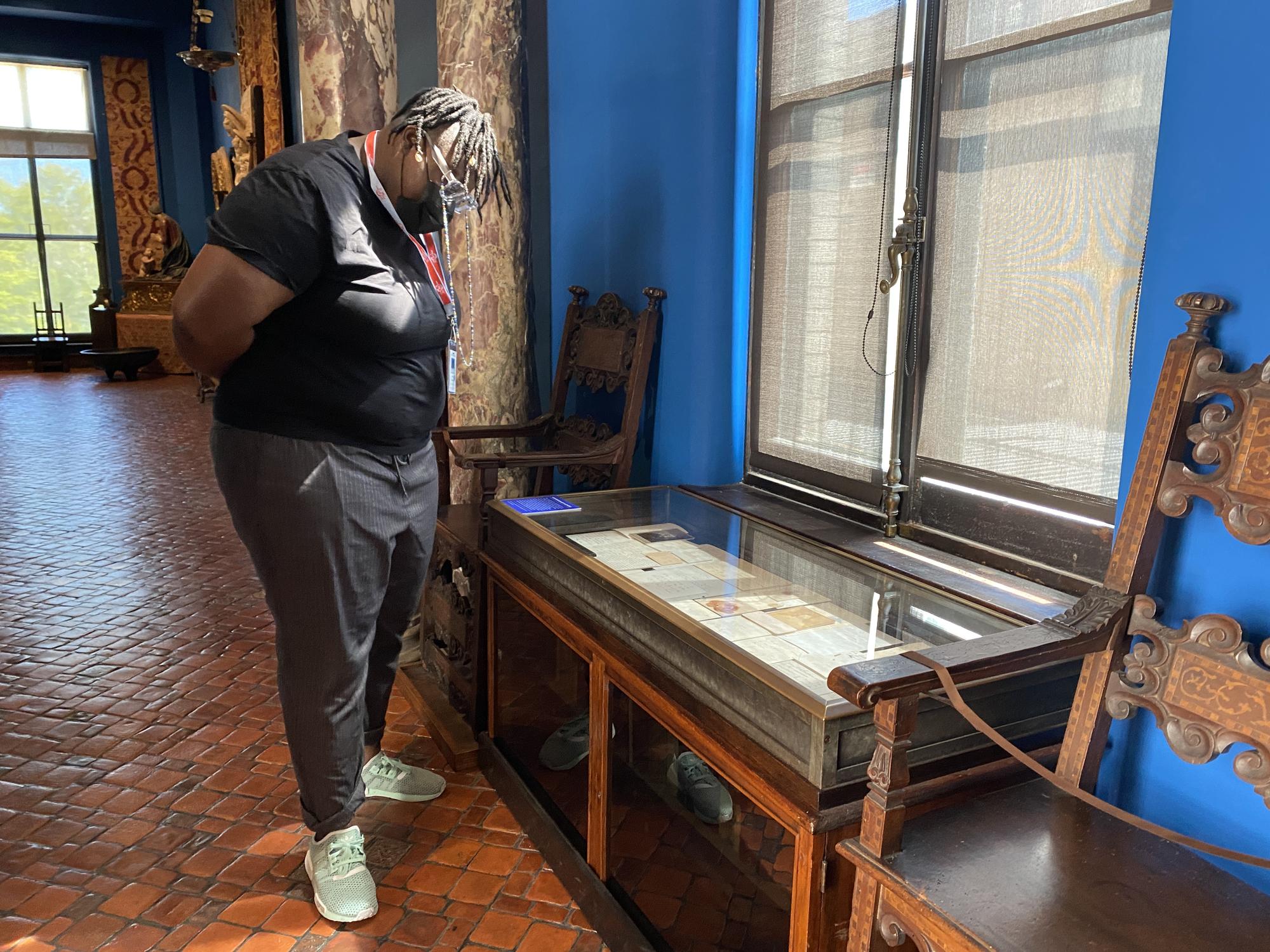 Porsha Olayiwola looks at a number of papers in a glass case at the Isabella Stewart Gardner Museum. 