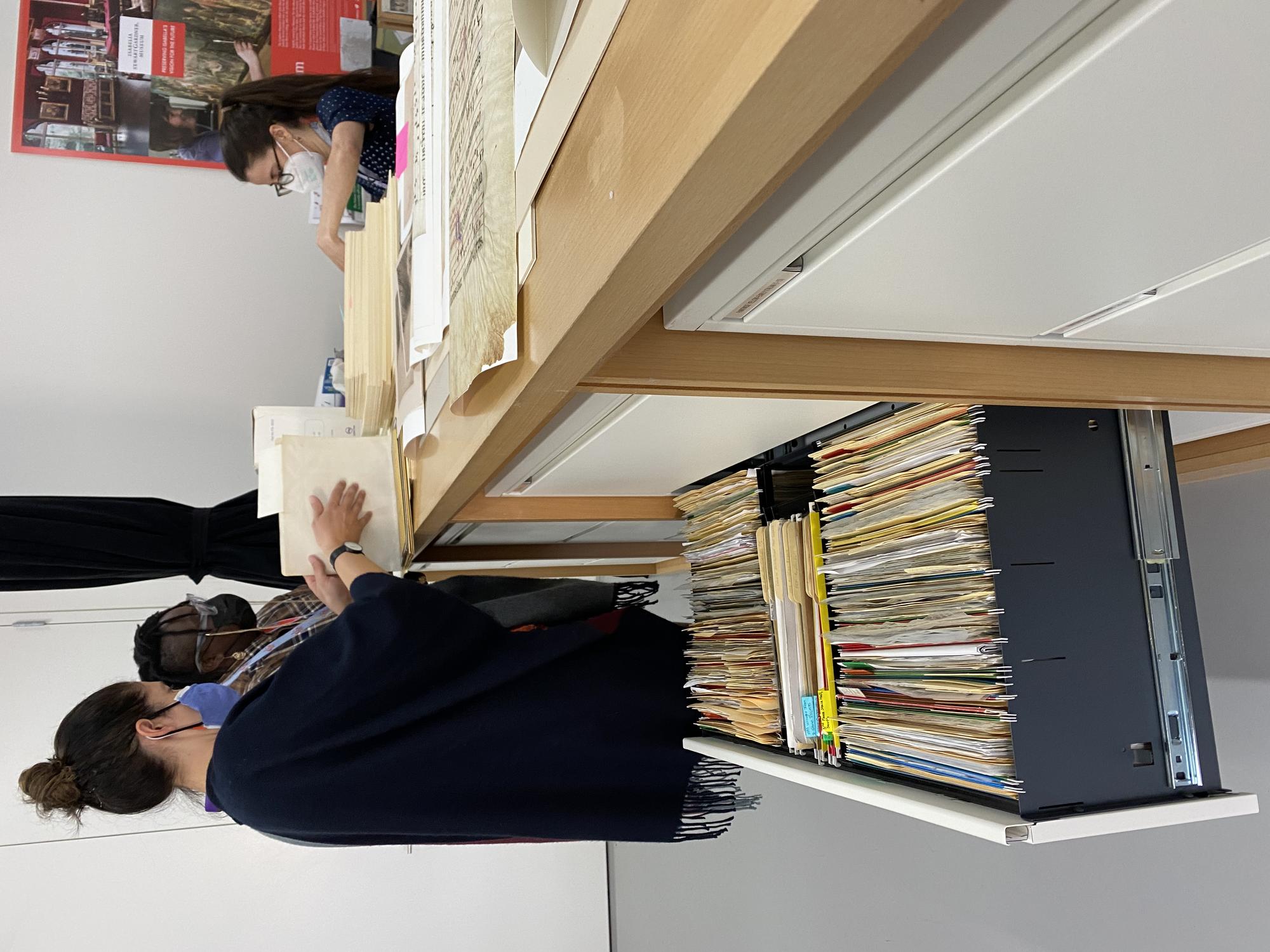 Porsha Olayiwola and two archivists organizing files. 