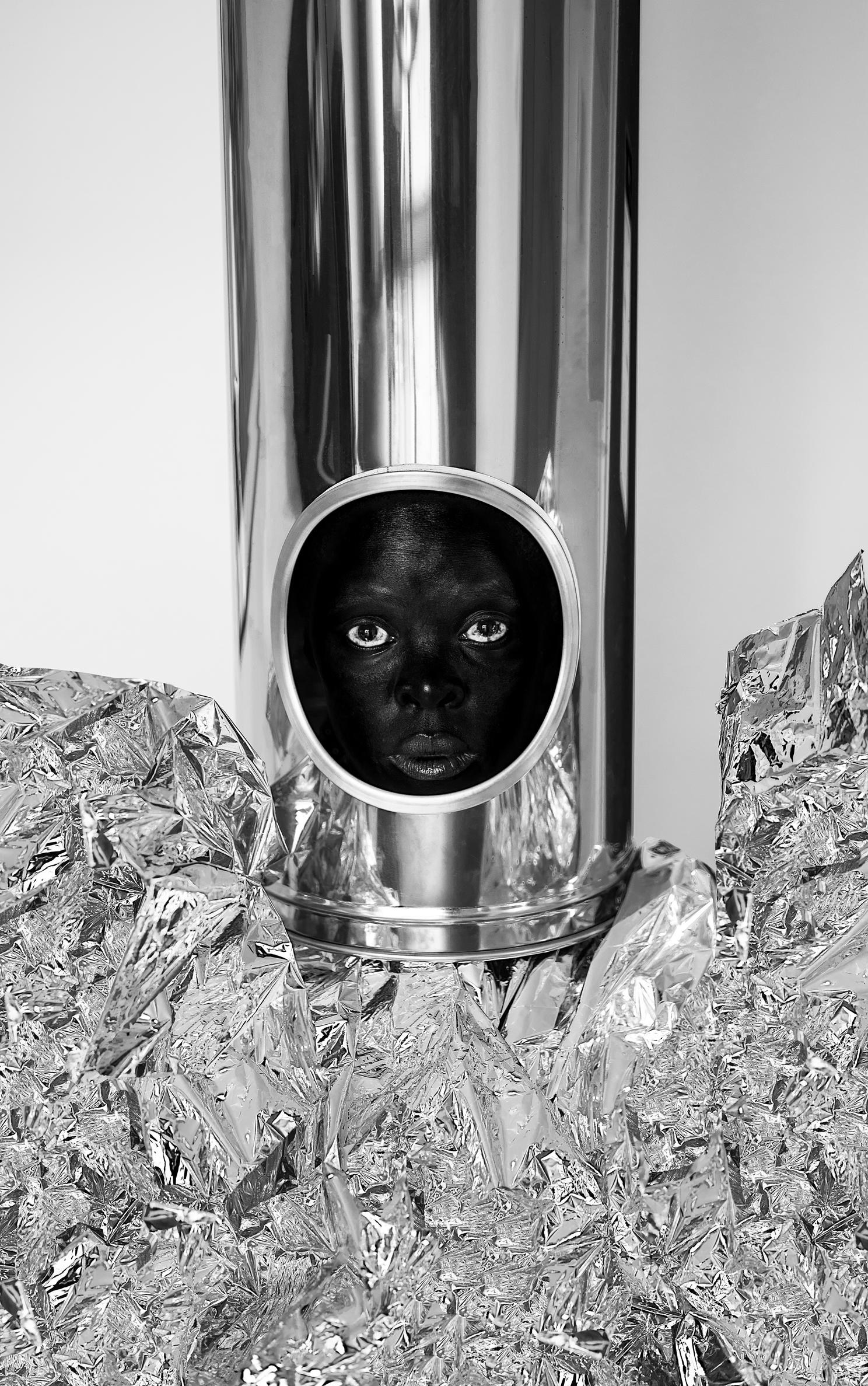 A photo of a person in a tube with a hole, surrounded by aluminium foil.