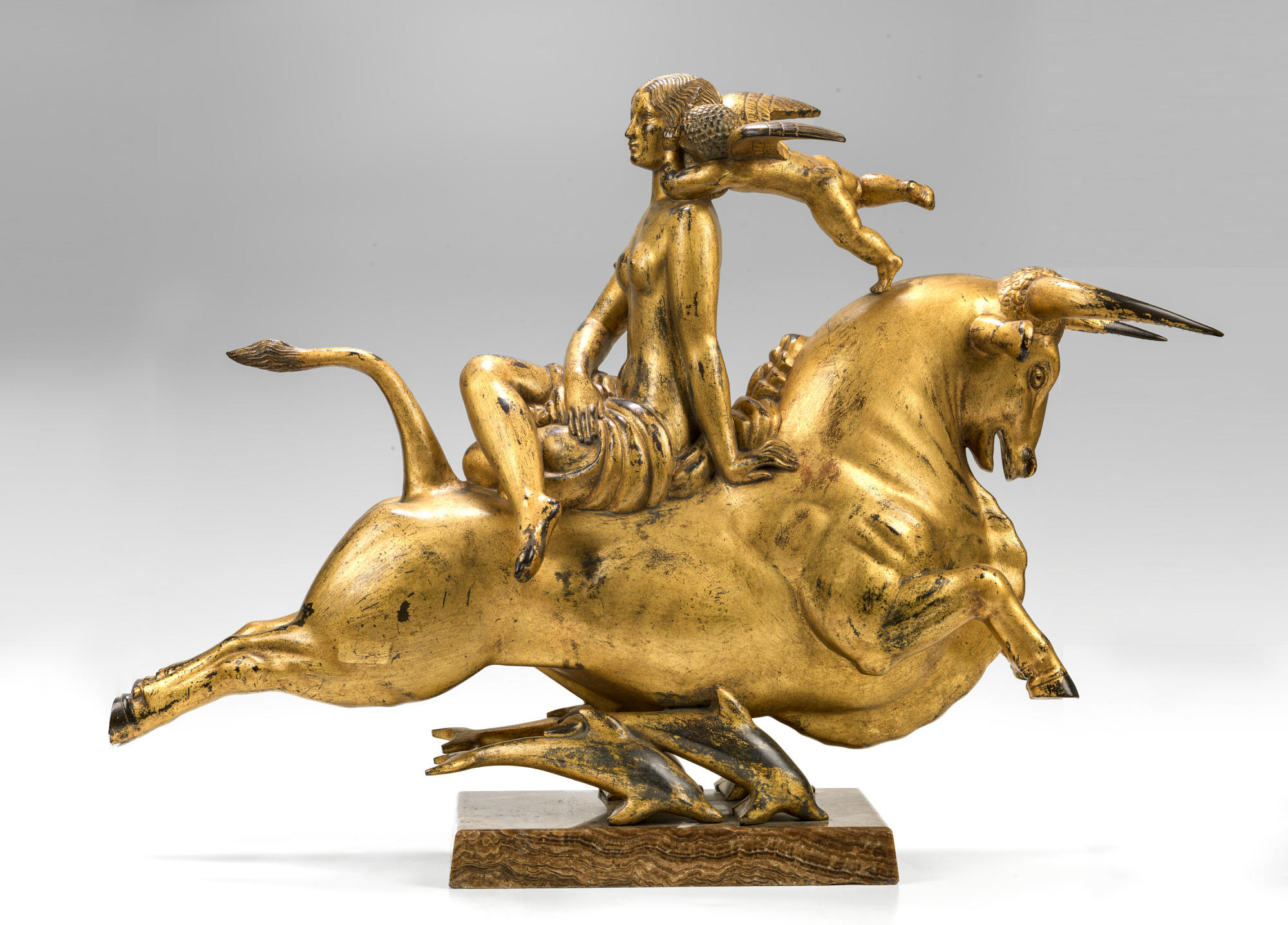 A gold statue of Europa on a bull.