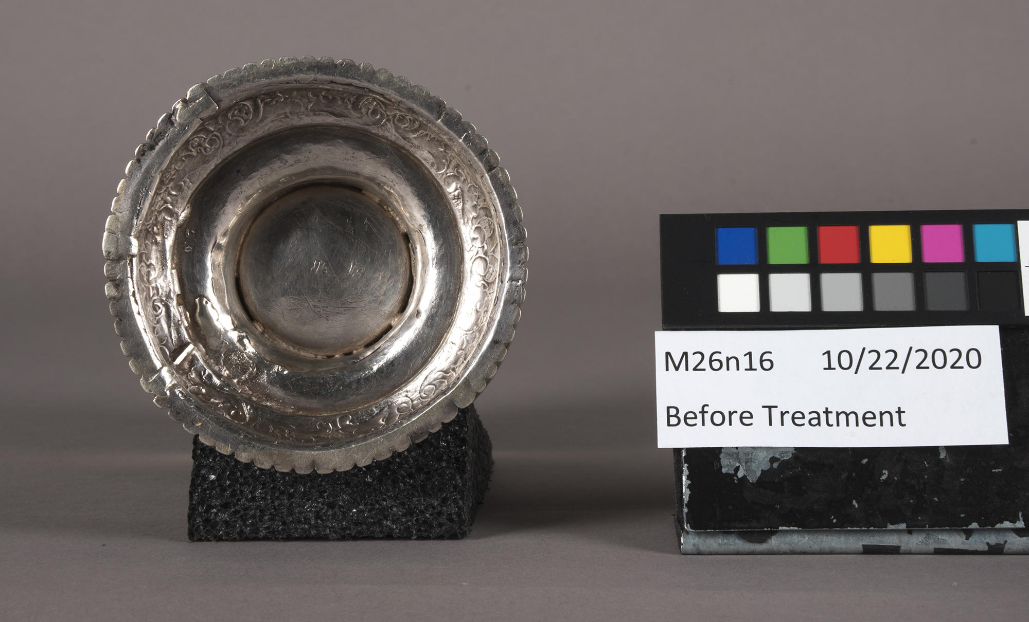 A silver cup next to a black card with colors.