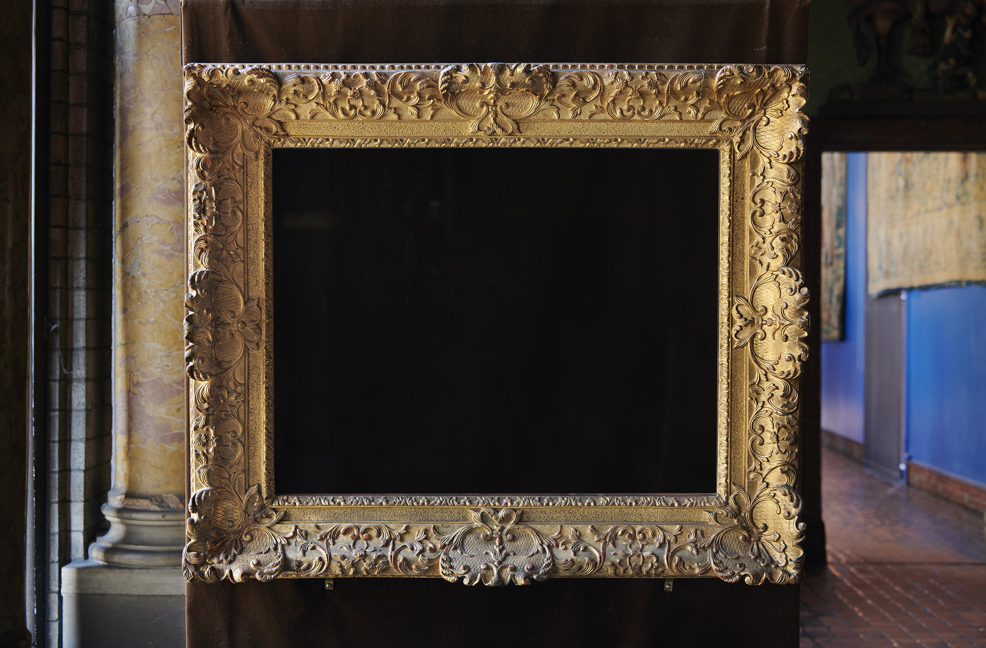 An empty frame on a black wall. 