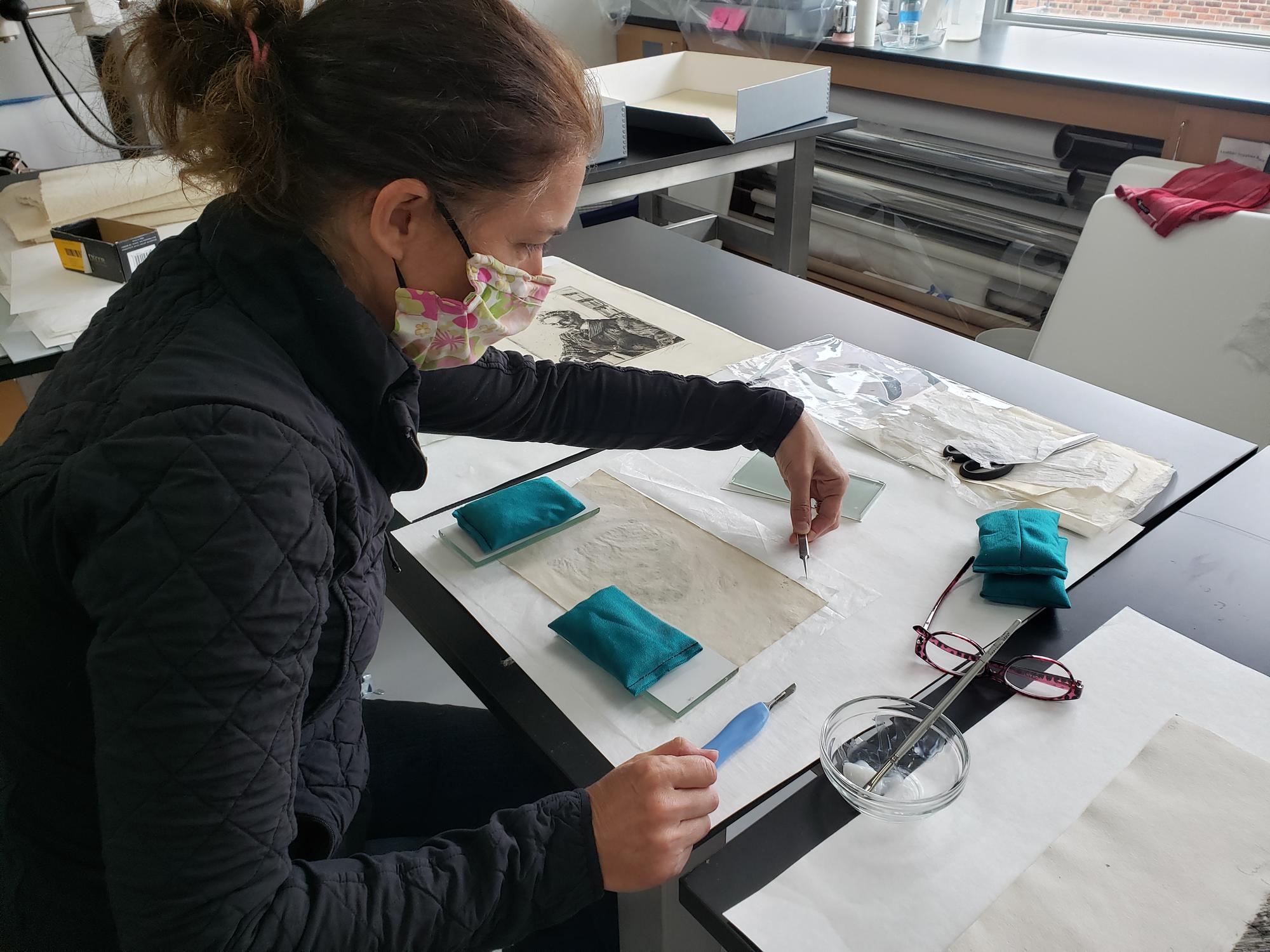 Deborah LaCamera mending a print with Japanese paper in 2020