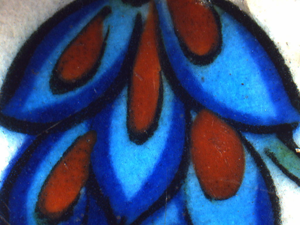 A magnified view of the Turkish tile with the intersection of blue, turquoise, red, and black glazes