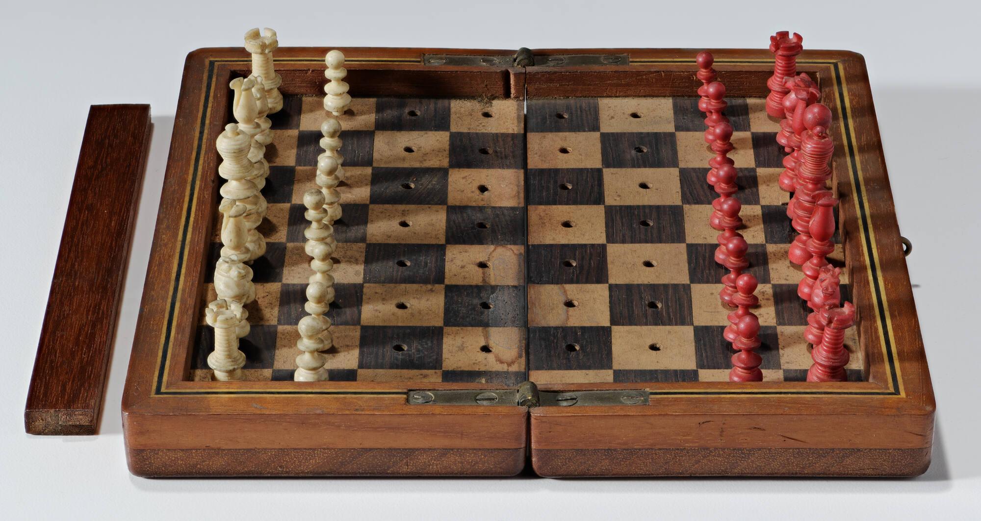 A small chess set with red and white pieces.