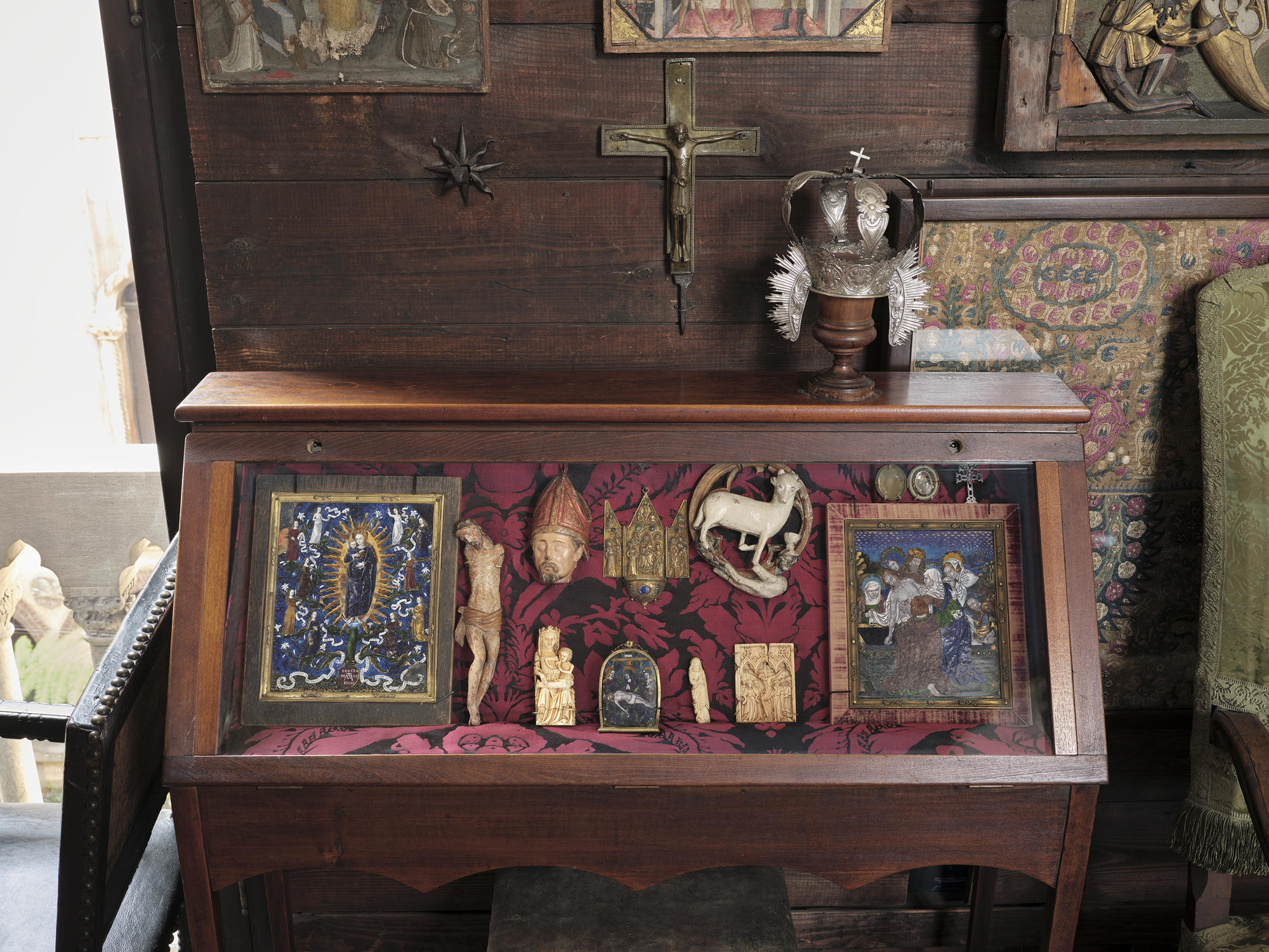 A wooden case with a glass front containing enamels of the Virgin and Child, the Pieta and the Entombment.