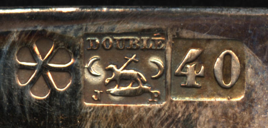 The embossed hallmark with three parts. On the left is a six petal flower. In the middle is the word Doublé above a lamb and the initials JP. On the right is the number 40.
