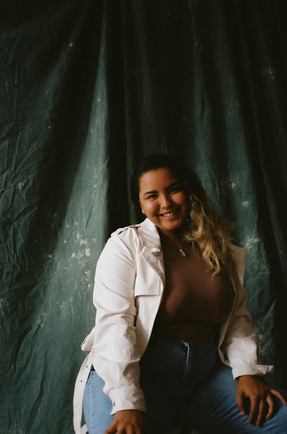 Photo of a person against a green backdrop. 