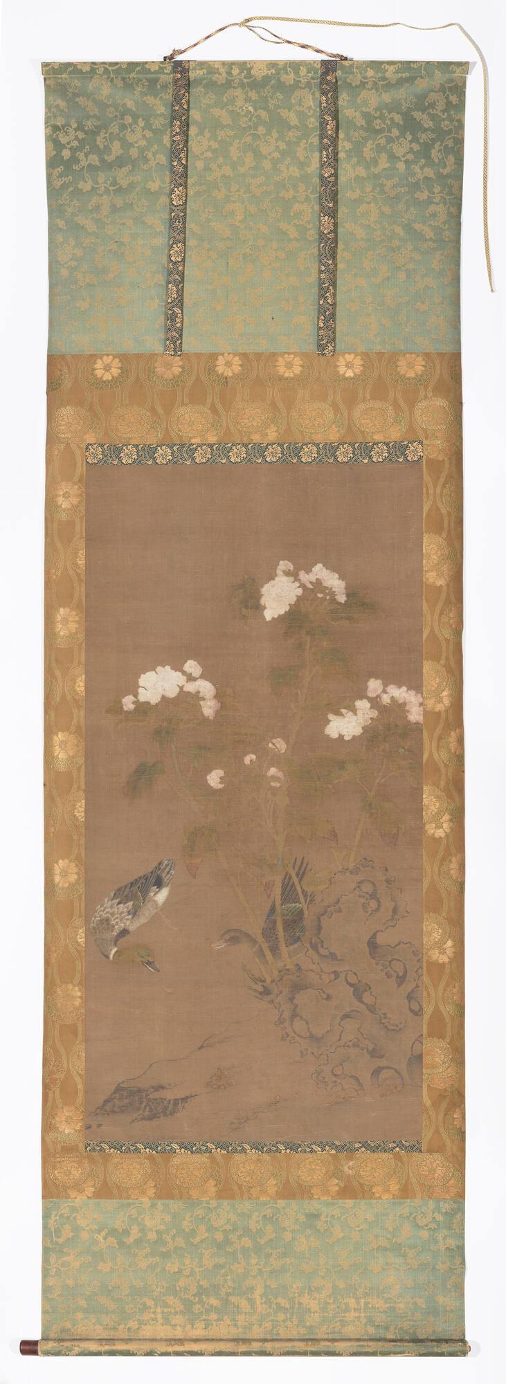 ‘Peonies and Ducks,’ mounted as a hanging scroll, longer than it is wide, showing a male and female duck swimming beside tall peony blossoms.