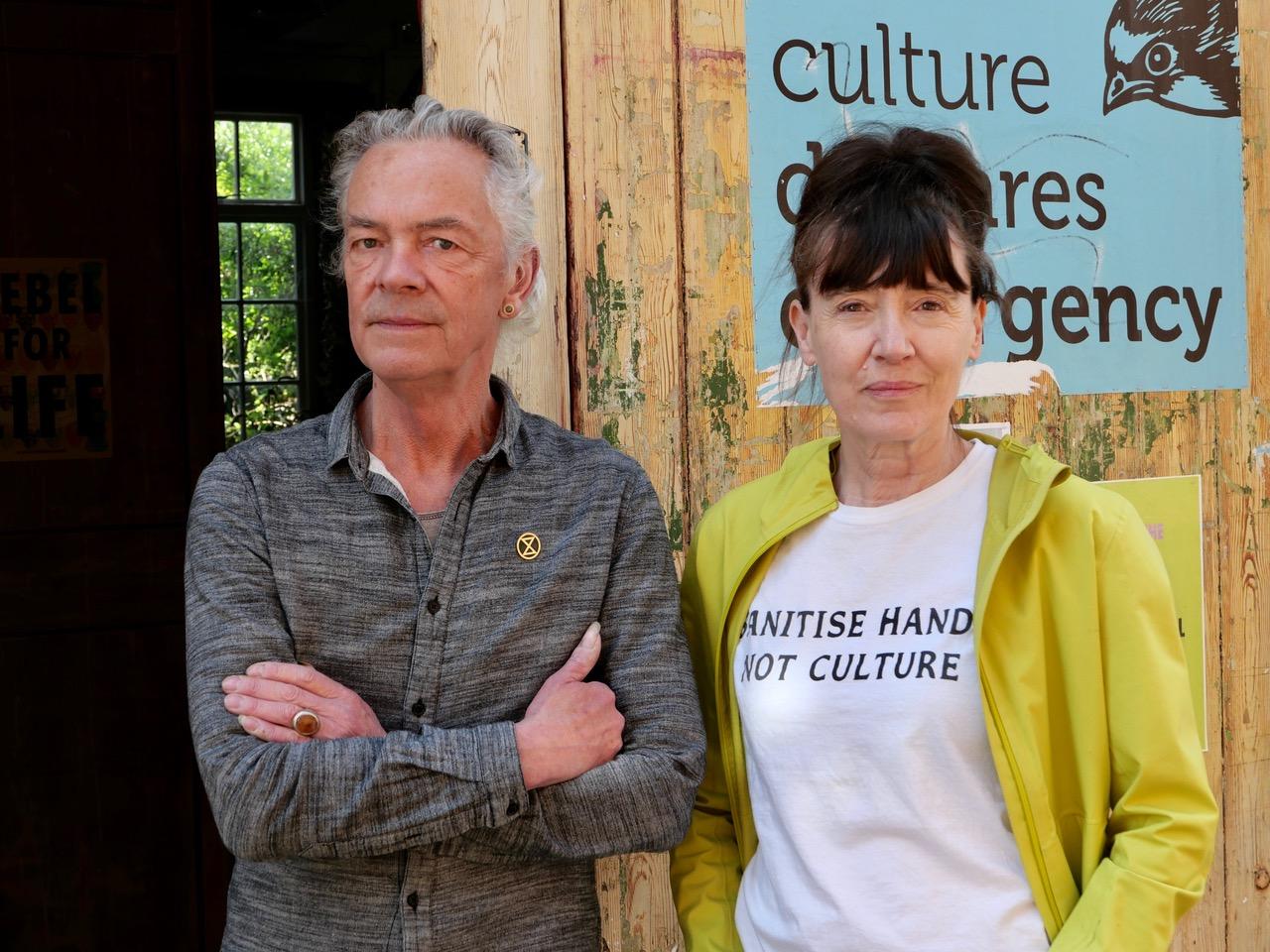 Photo of 2 people standing in front of a building. 