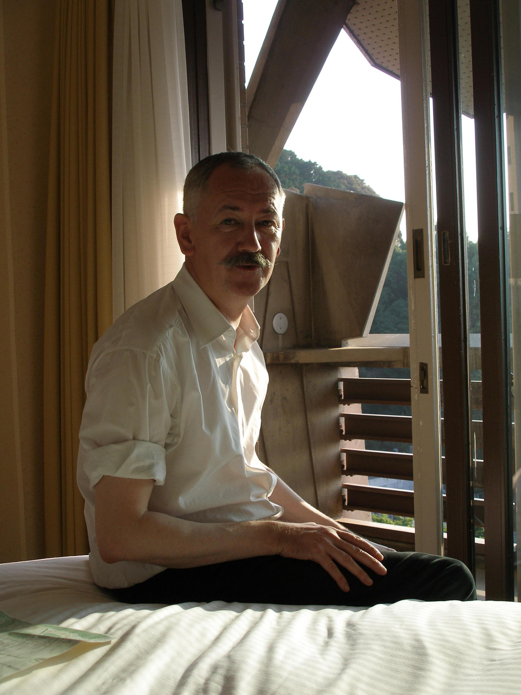 Photo of a person sitting in front of a window. 