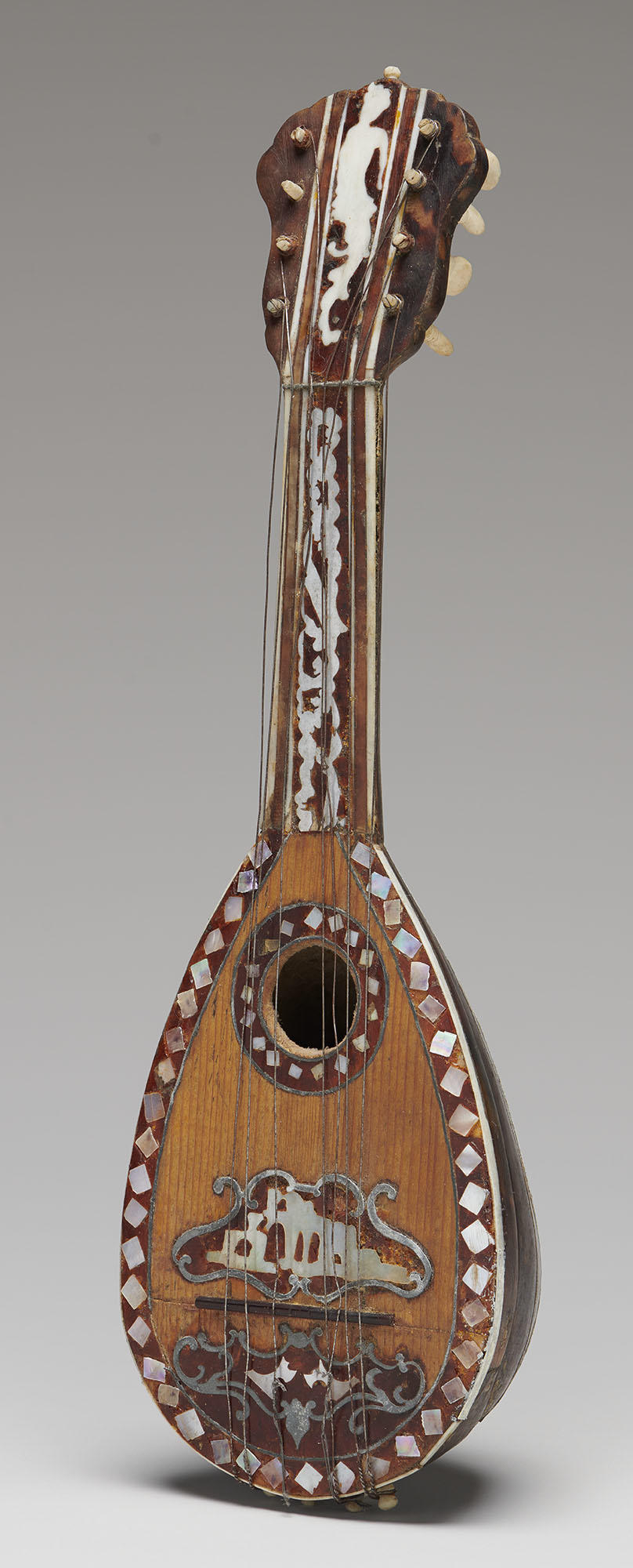 A miniature stringed instrument at the Isabella Stewart Gardner Museum, made of wood and tortoise shell, with mother-of-pearl designs shown after conservation.