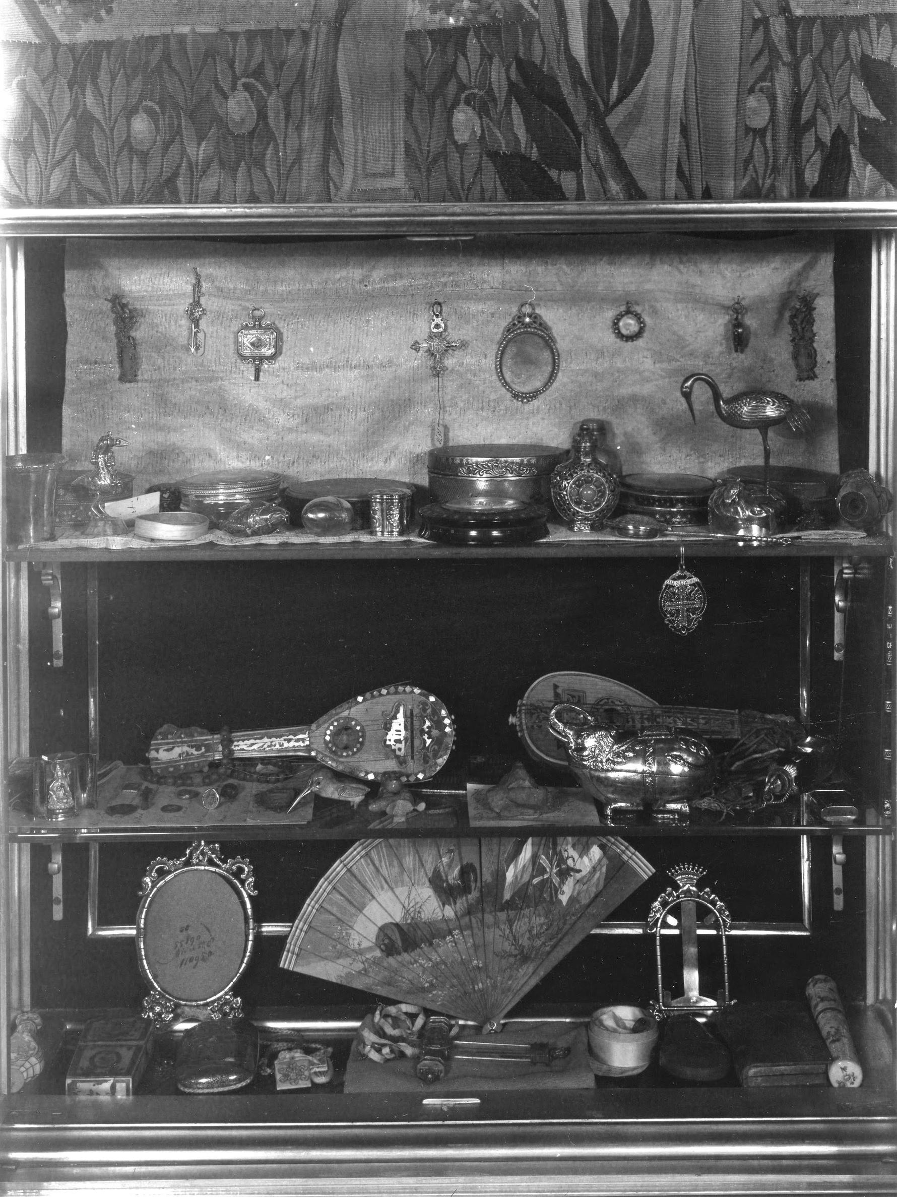 A black and white photograph of a vitrine in the Isabella Stewart Gardner Museum with assorted small objects displayed in its interior.