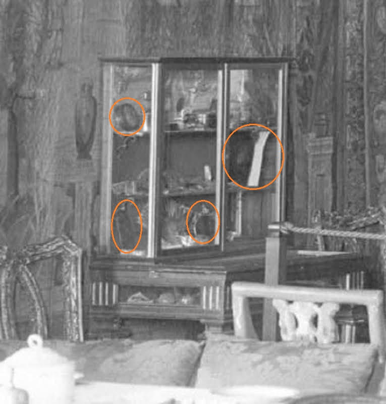 A black and white photograph of a vitrine in the Isabella Stewart Gardner Museum with assorted small objects displayed in its interior. Red circles indicate objects that were moved by 1942.