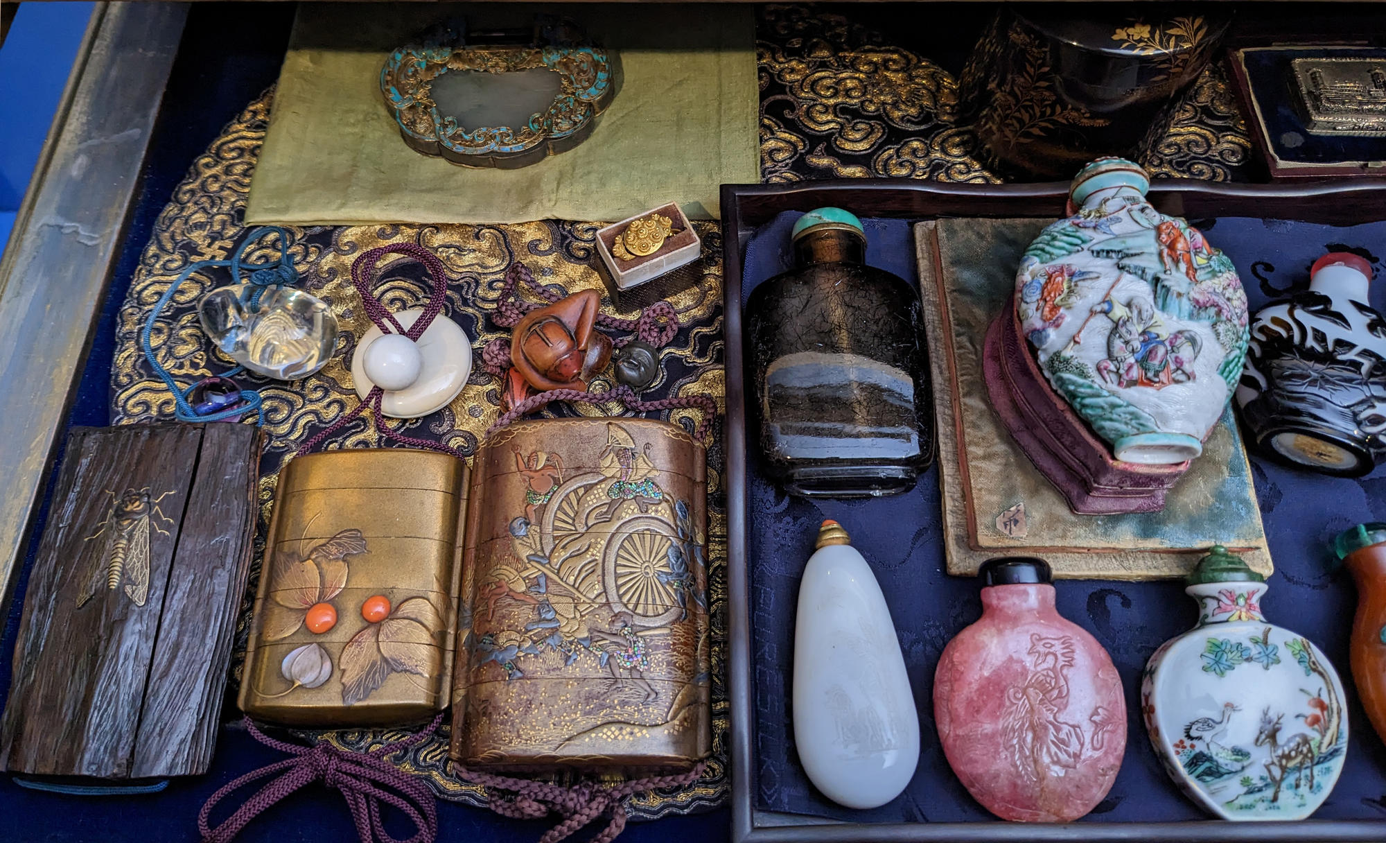 Gilt case with assorted small bottles made of porcelain, stone, and Asian lacquer curated by Isabella Stewart Gardner. 