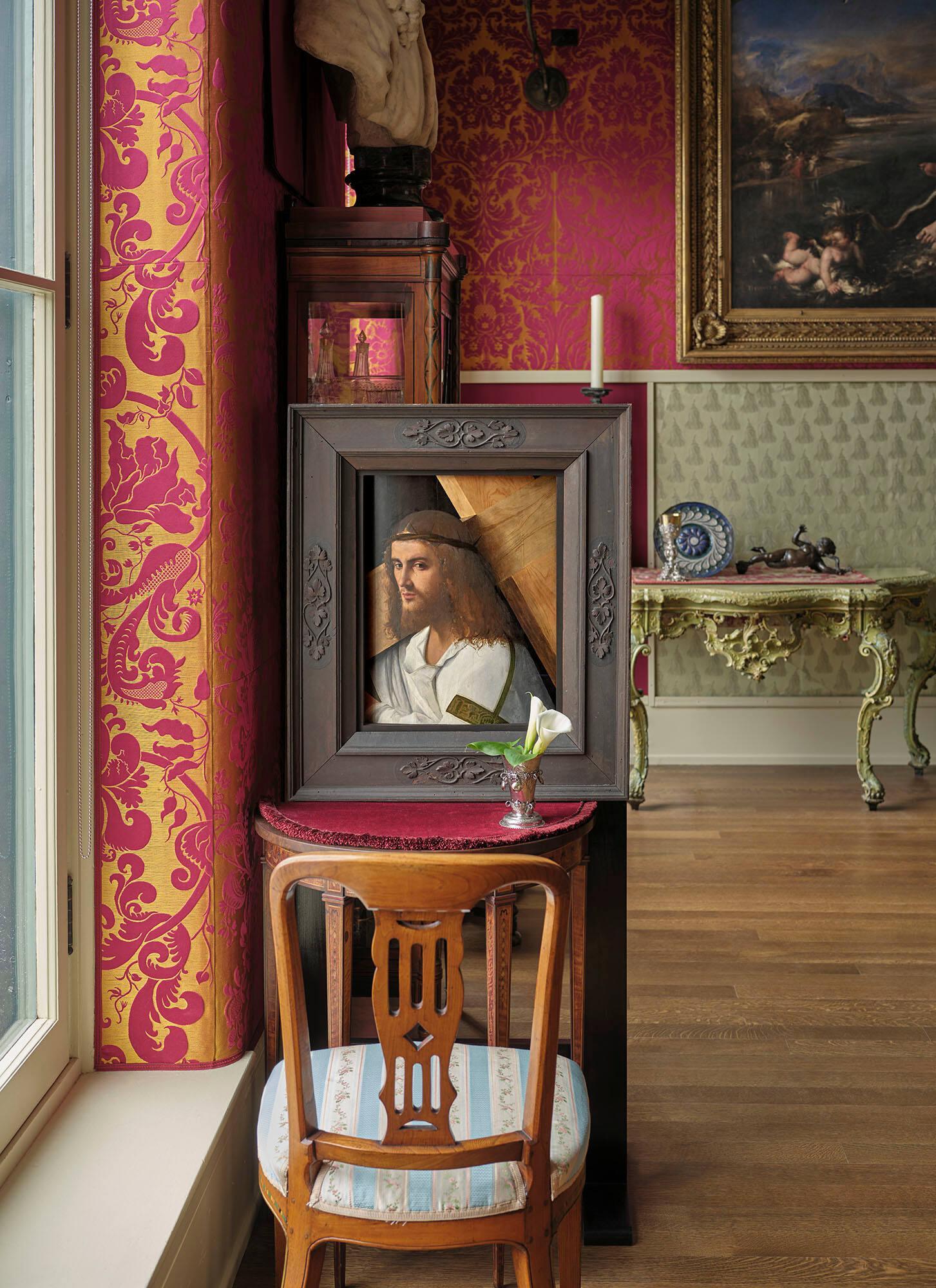 A corner of a gallery, the Titian Room, in the Isabella Stewart Gardner Museum showing a small table with a painting of the head of Jesus with tears on his face. In front of the painting is a small Norwegian silver beaker with a flower.
