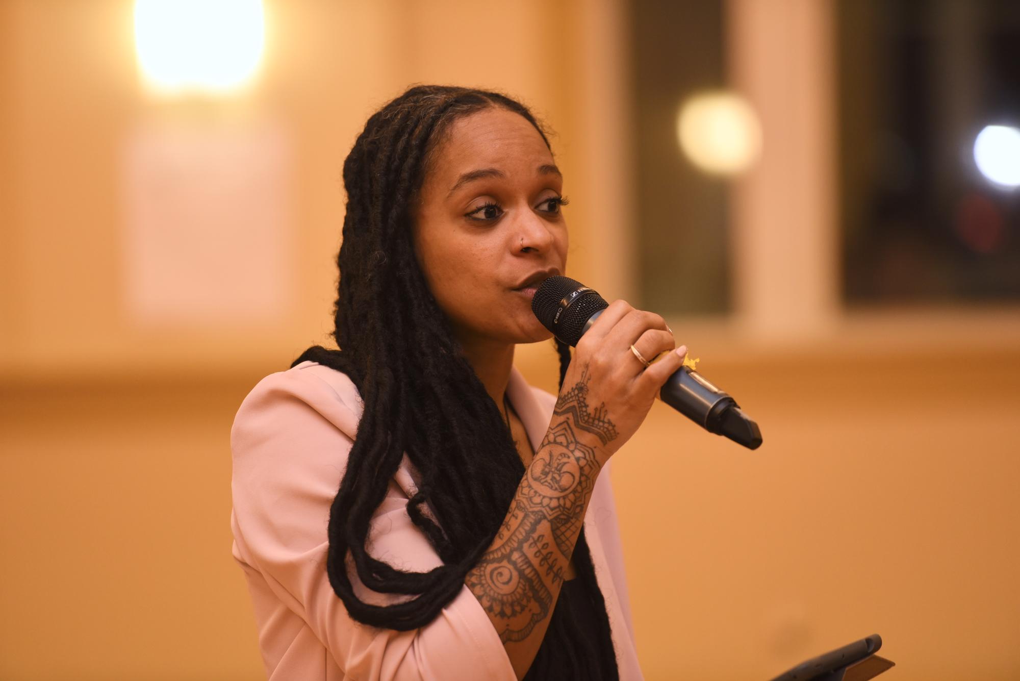 Photo of a woman talking on a microphone. 