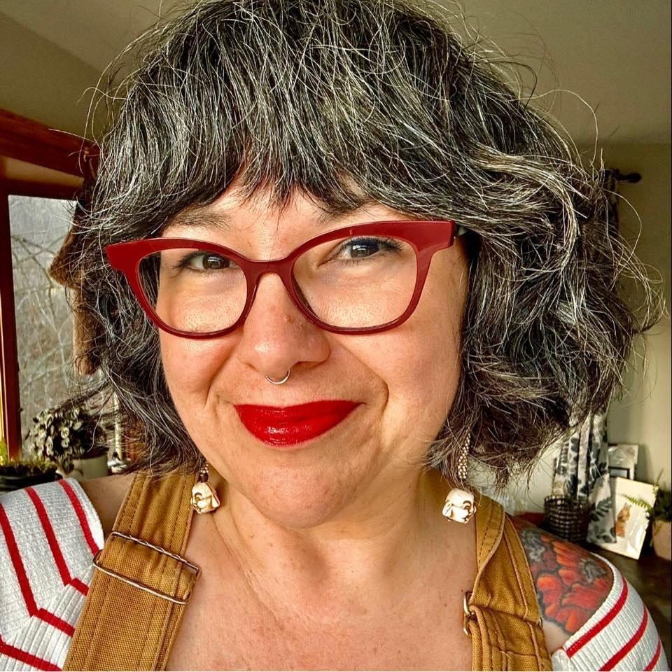 Photo of a person wearing red glasses.