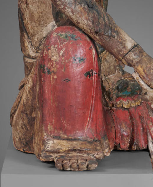 Detail of Guanyin’s upright bent knee, showing red pants with black, green, and white painted cloud design.