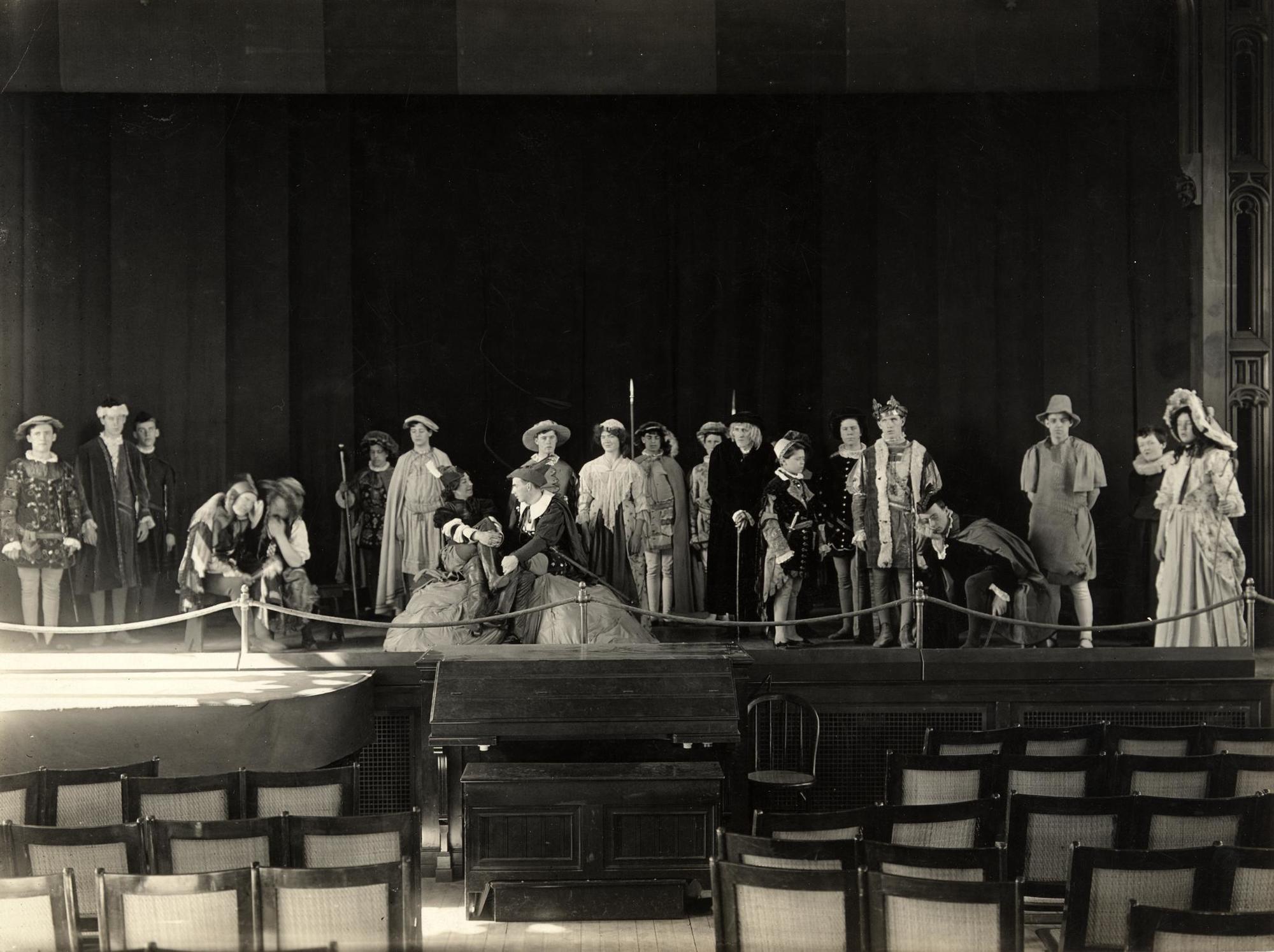 Twenty-one students from Perkins School for the Blind in Elizabethan costume stand on a stage.