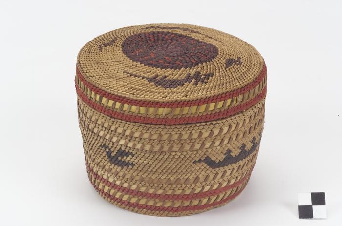 A lidded cylindrical woven basket with bird motifs made by a Quinault weaver.