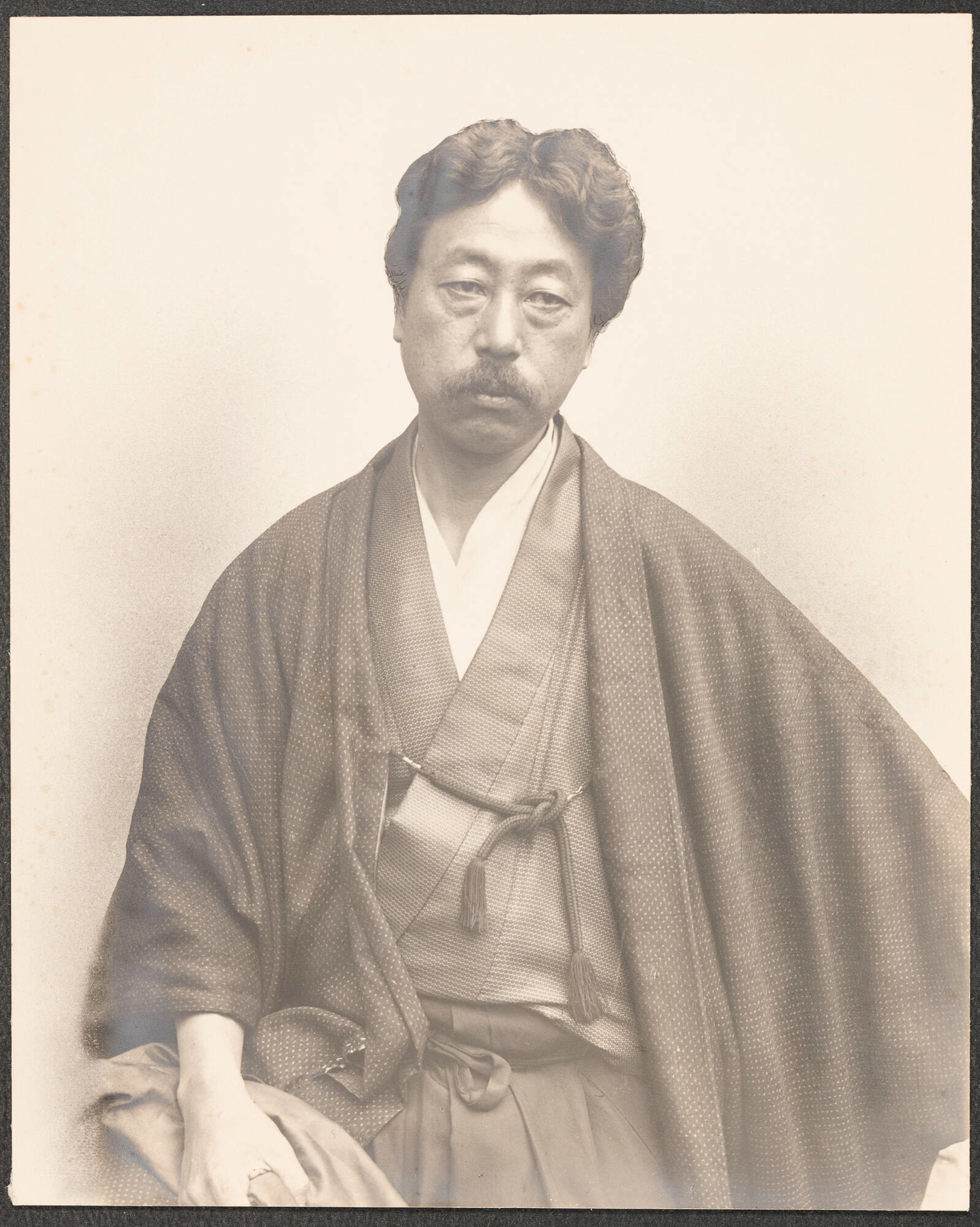 A black and white portrait photograph of a Japanese man, Okakura Kakuzō, wearing Japanese robes.