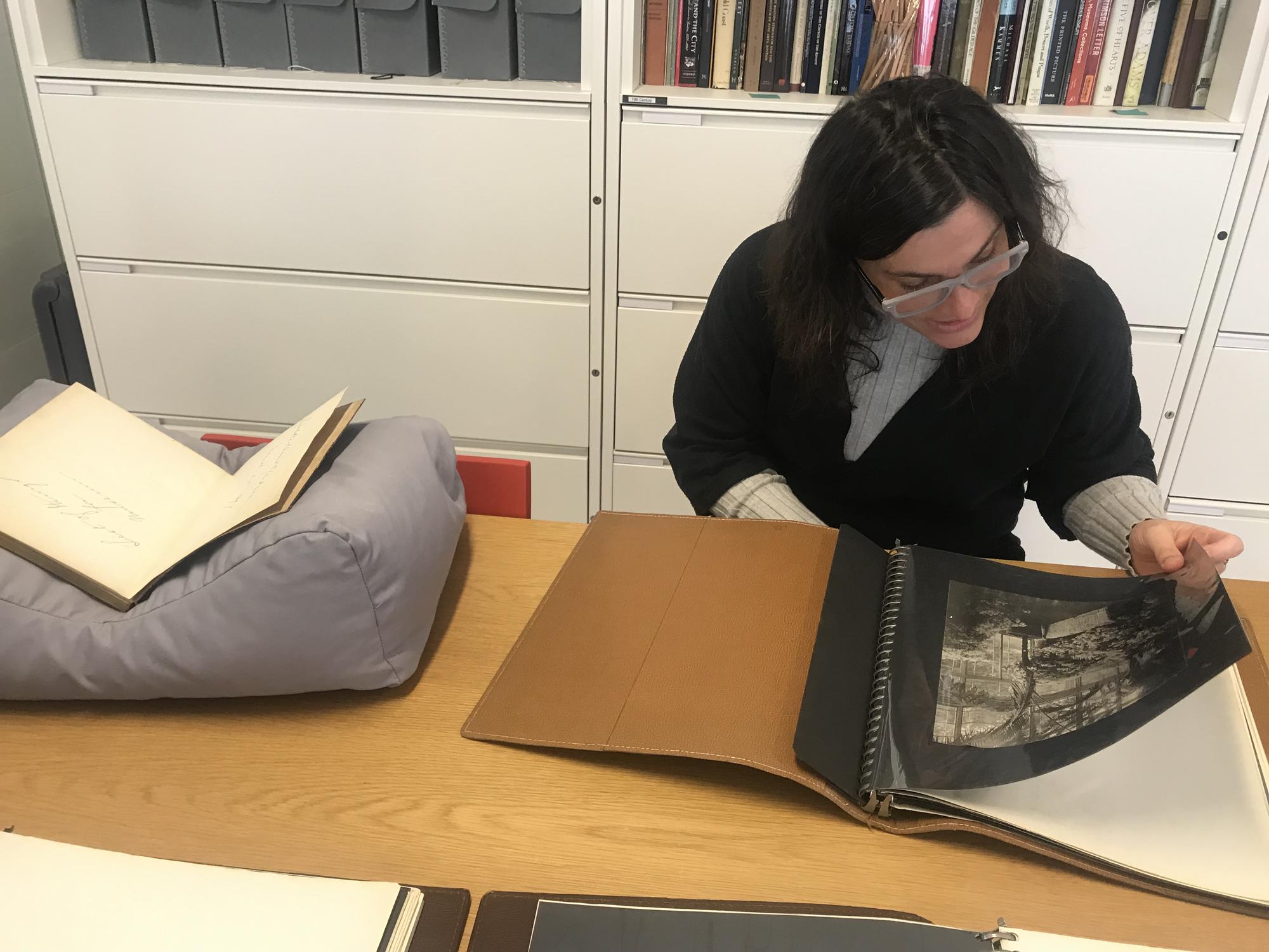 Nicole Cherubini looking at Gardner’s photo album of Green Hill taken by Thomas Marr and Son, 2019