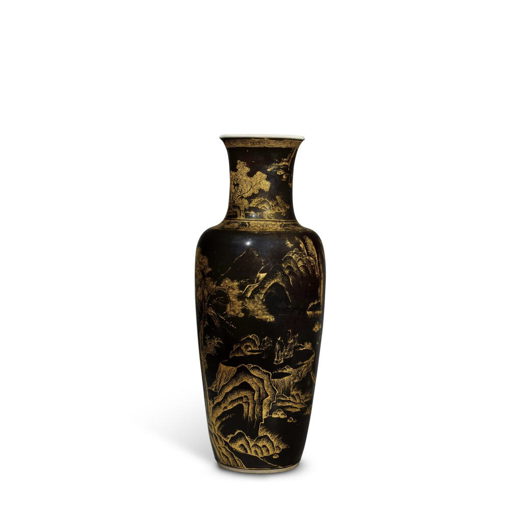 A black vase, taller than it is wide, with a rim that turns outward, a slim neck, and a shoulder that slopes gradually to a narrower base with gold landscape decoration.