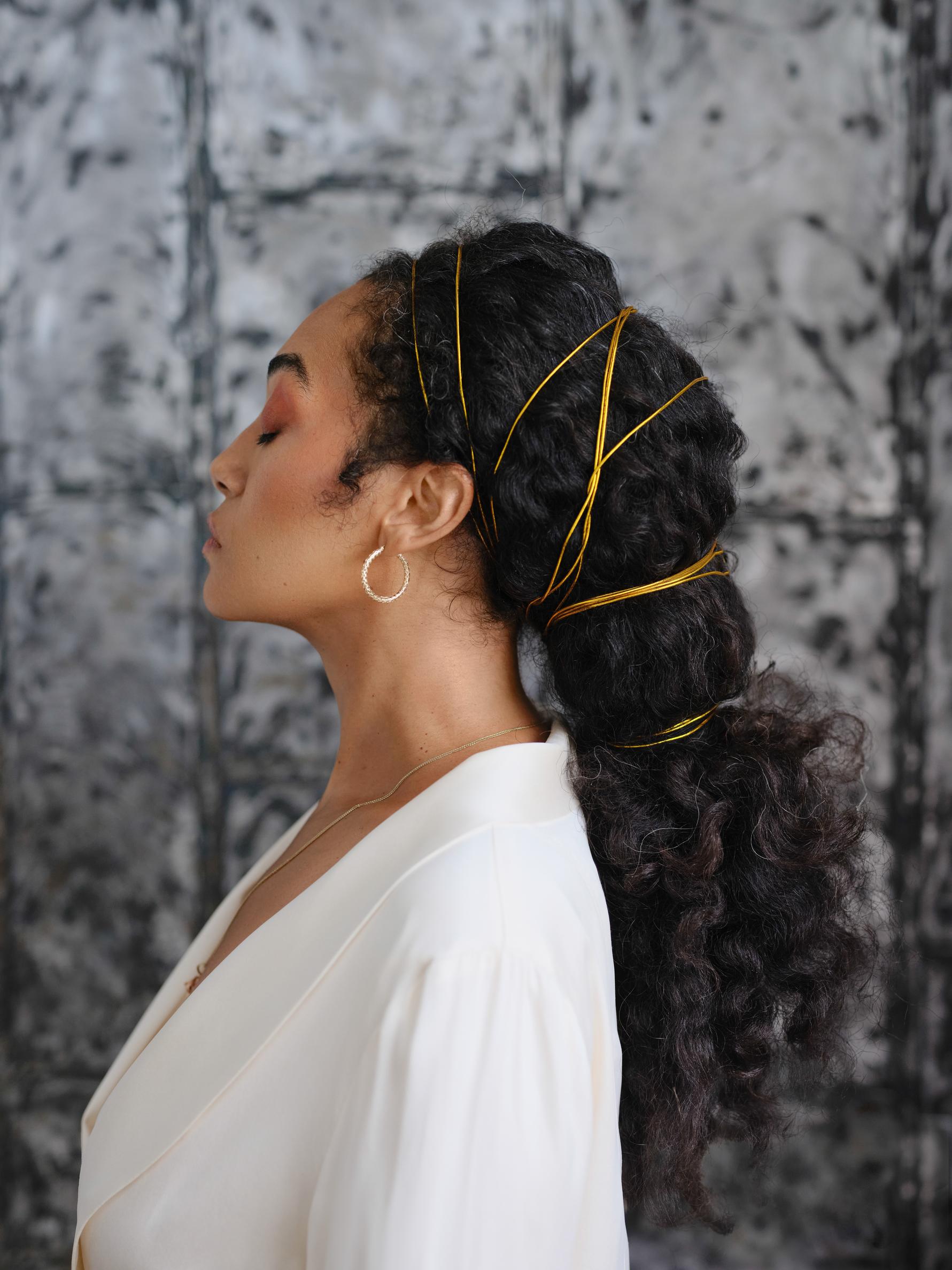 Side view image of Johnette Marie in a white dress