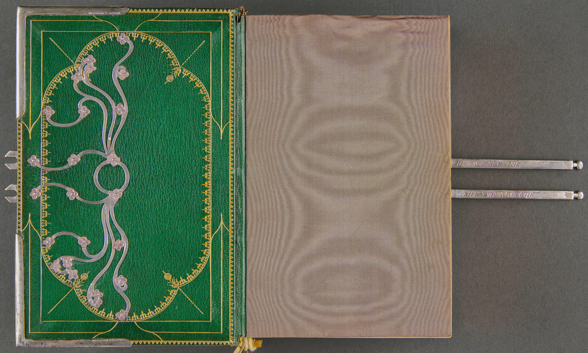 A book bound in green leather with silver decoration and a silk lining.