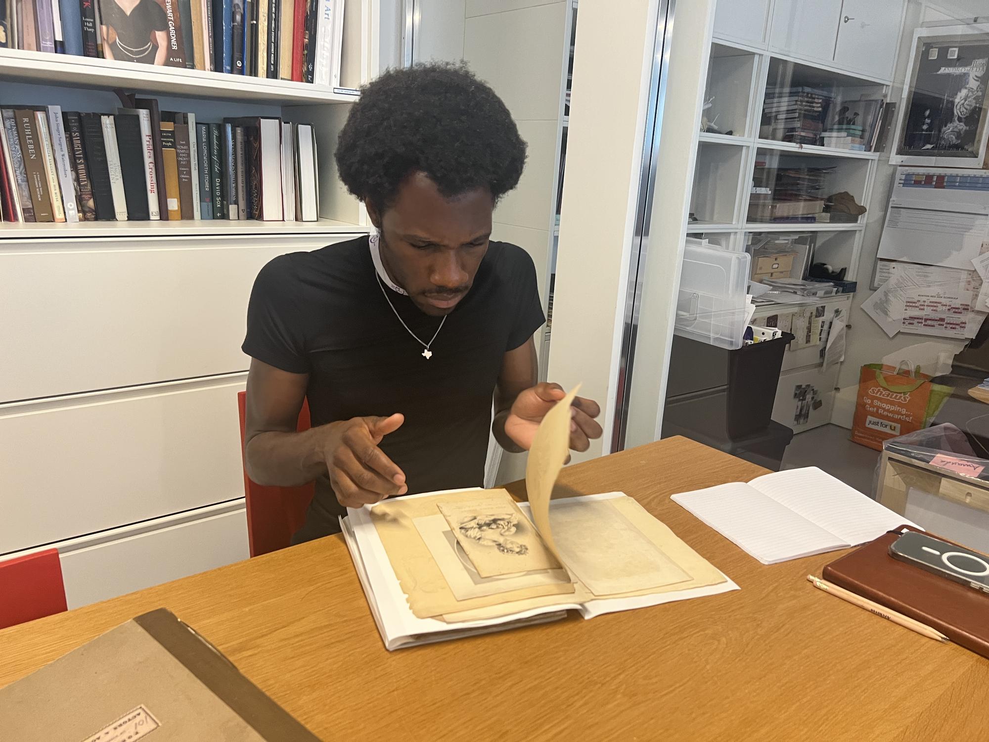 Man in black shirt inspecting a historical book 